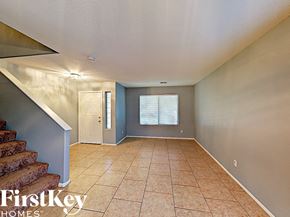 Phoenix house for rent - an empty living room with a staircase and tiled floors