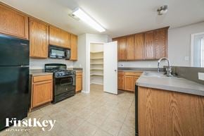 Hockley house for rent - a kitchen with wooden cabinets and black appliances and a sink