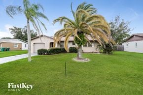 Port Charlotte house for rent - a home with palm trees in the yard and a lawn