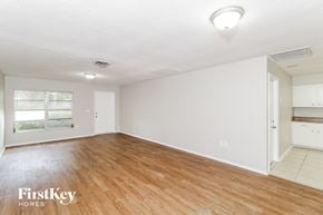Port Charlotte house for rent - the living room and dining room with wood flooring and white walls