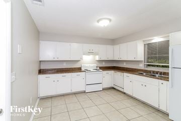 Port Charlotte house for rent - a white kitchen with white appliances and white cabinets