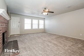 Lancaster house for rent - an empty living room with a fireplace and a ceiling fan