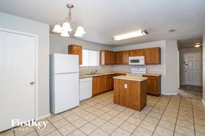 Lancaster house for rent - a kitchen with white appliances and wooden cabinets