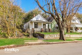Kansas City house for rent - a white and green house with a tree in front of it
