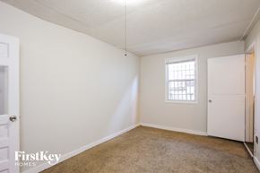 Kansas City house for rent - a bedroom with white walls and carpet and a window