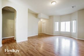 Homestead house for rent - an empty living room with wood floors and white walls