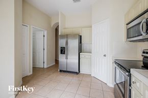 Homestead house for rent - a kitchen with white cabinets and a stainless steel refrigerator