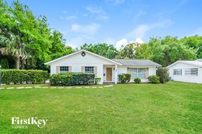 Mount Dora house for rent - a white house with a green lawn and trees