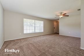 Mount Dora house for rent - an empty living room with carpet and a ceiling fan