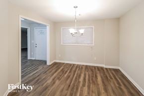 Decatur house for rent - an empty living room with wood flooring and a door to a hallway