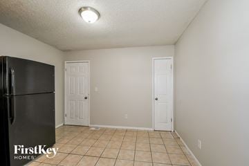 Florissant house for rent - a kitchen with a refrigerator and a white door