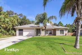 North Port house for rent - a house with a lawn and palm trees