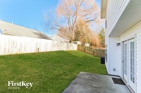Winston-Salem house for rent - a backyard with green grass and a fence and a driveway