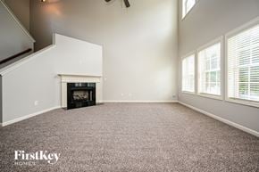 Snellville house for rent - A spacious living room with a fireplace and a carpeted floor.
