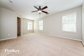 Snellville house for rent - A spacious room with a ceiling fan and two windows.