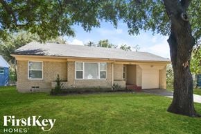 Dallas house for rent - a small brick house with a tree in the yard