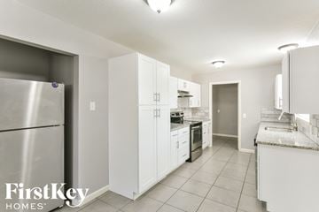 Dallas house for rent - a white kitchen with stainless steel appliances and white cabinets