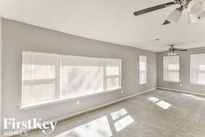 Dallas house for rent - a living room with a large window and a ceiling fan