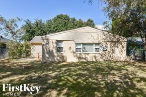 Dallas house for rent - a small house in a backyard with a yard and trees