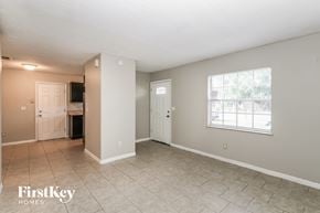 Tampa house for rent - the living room and dining room of a house with a large window and tile floor
