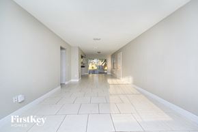 Largo house for rent - A long hallway with white walls and tile flooring.