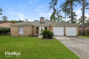 Spring house for rent - a brick house with white garage doors and a lawn