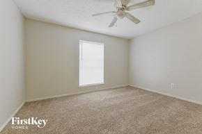 Spring house for rent - a bedroom with carpet and a ceiling fan