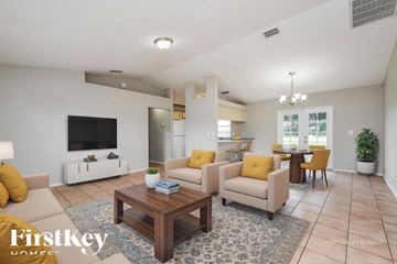 Lehigh Acres house for rent - A living room with a wooden coffee table and yellow cushions.