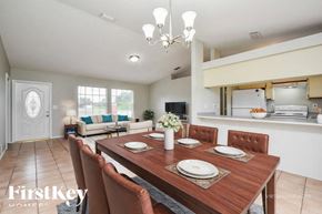 Lehigh Acres house for rent - A dining room with a wooden table set for four.