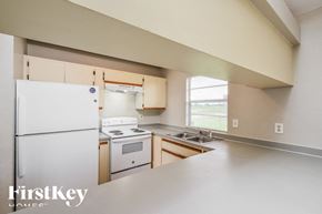 Lehigh Acres house for rent - A kitchen with a white refrigerator and a stove top oven.