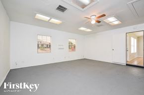Lehigh Acres house for rent - A spacious room with a ceiling fan and lighting fixtures.