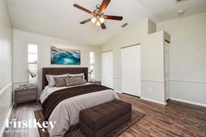 Lehigh Acres house for rent - A bedroom with a large bed and a ceiling fan.