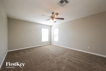 Cape Coral house for rent - a living room with a ceiling fan and a carpet