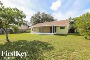 Eustis house for rent - A house with a lawn and trees in front of it.
