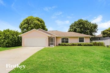 Port St. Lucie house for rent - a beige house with a lawn in front of it