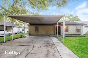 Pearland house for rent - A covered patio area with a concrete floor and a white pergola.
