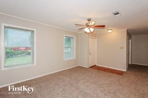Pearland house for rent - A room with a carpeted floor, a ceiling fan, and a window with blinds.