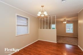 Pearland house for rent - A room with wooden floors and a hanging light fixture.
