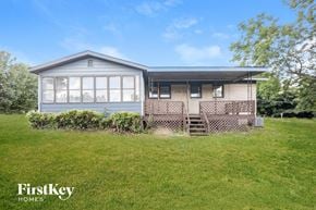 Ellenwood house for rent - A house with a blue roof and a porch with a wooden railing.