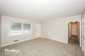 Ellenwood house for rent - A room with a carpet floor and a doorway leading to another room.