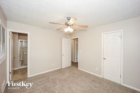 Ellenwood house for rent - A spacious room with a ceiling fan and carpeted floor.
