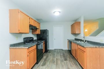 Indianapolis house for rent - A kitchen with wooden cabinets and a black refrigerator.