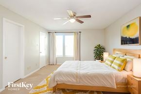 Indianapolis house for rent - A bedroom with a bed, a ceiling fan, and a painting on the wall.