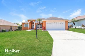 Lakeland house for rent - a house with a lawn and a driveway and a garage door