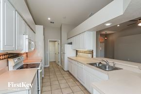 Lakeland house for rent - a large kitchen with white cabinets and counters and a sink