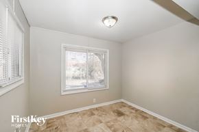 Indianapolis house for rent - the living room of a home with a large window and wooden floors