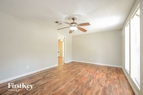 Adamsville house for rent - A room with wooden floors and a ceiling fan.