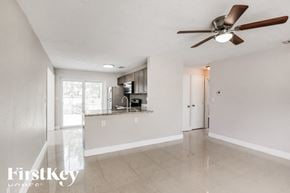 Pompano Beach house for rent - an empty living room and kitchen with a ceiling fan