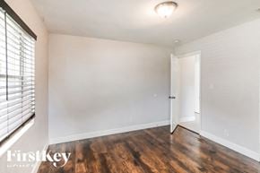 Pompano Beach house for rent - a bedroom with white walls and wood flooring and a door to a closet
