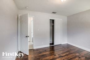 Pompano Beach house for rent - a living room with white walls and wood floors and a white door